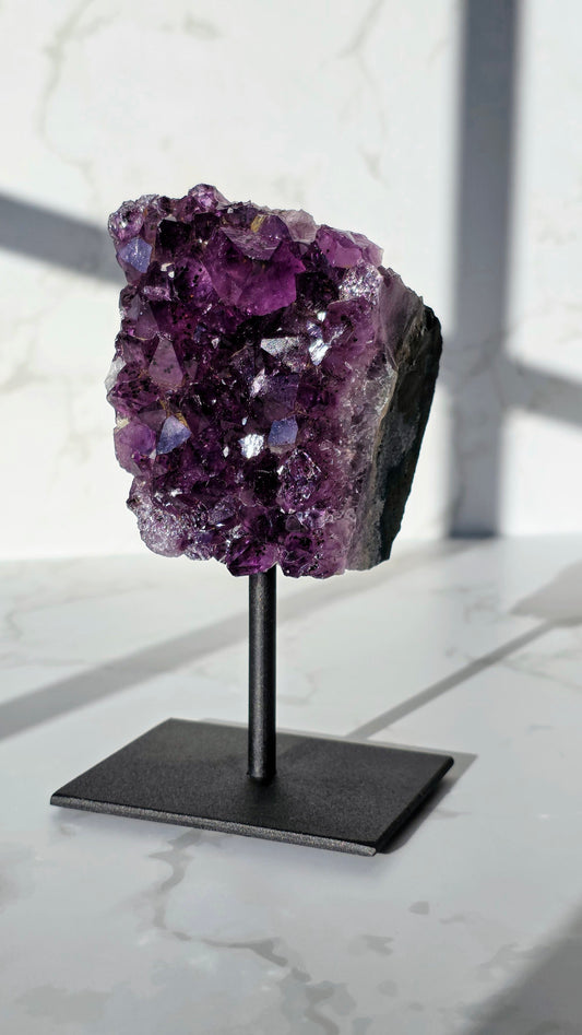 Amethyst Cluster mit Goethit-Einschlüssen auf Ständer